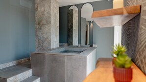 Ein modernes Badezimmer mit einem Steintonne, einem Spiegel und einer Holzauskładung.