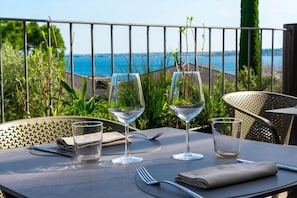 A table with two wine glasses and a fork, set on an outdoor terrace with a view of the sea. - Riva del Sole (Moniga del Garda)