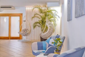 A modern interior with a hanging chair, a sofa, and a potted plant. - Riva del Sole (Moniga del Garda)