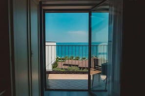 A balcony with a view of the sea and buildings.