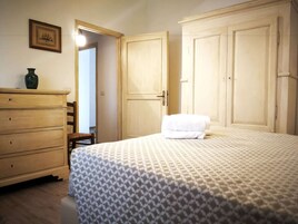 Un dormitorio con una cama, un aparador y dos puertas.