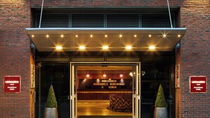 The exterior of the Leonard Hotel with a brick facade, a marquee sign, and two potted plants at the entrance. - Leonardo Hotel Dublin Parnell Street (Dublin)