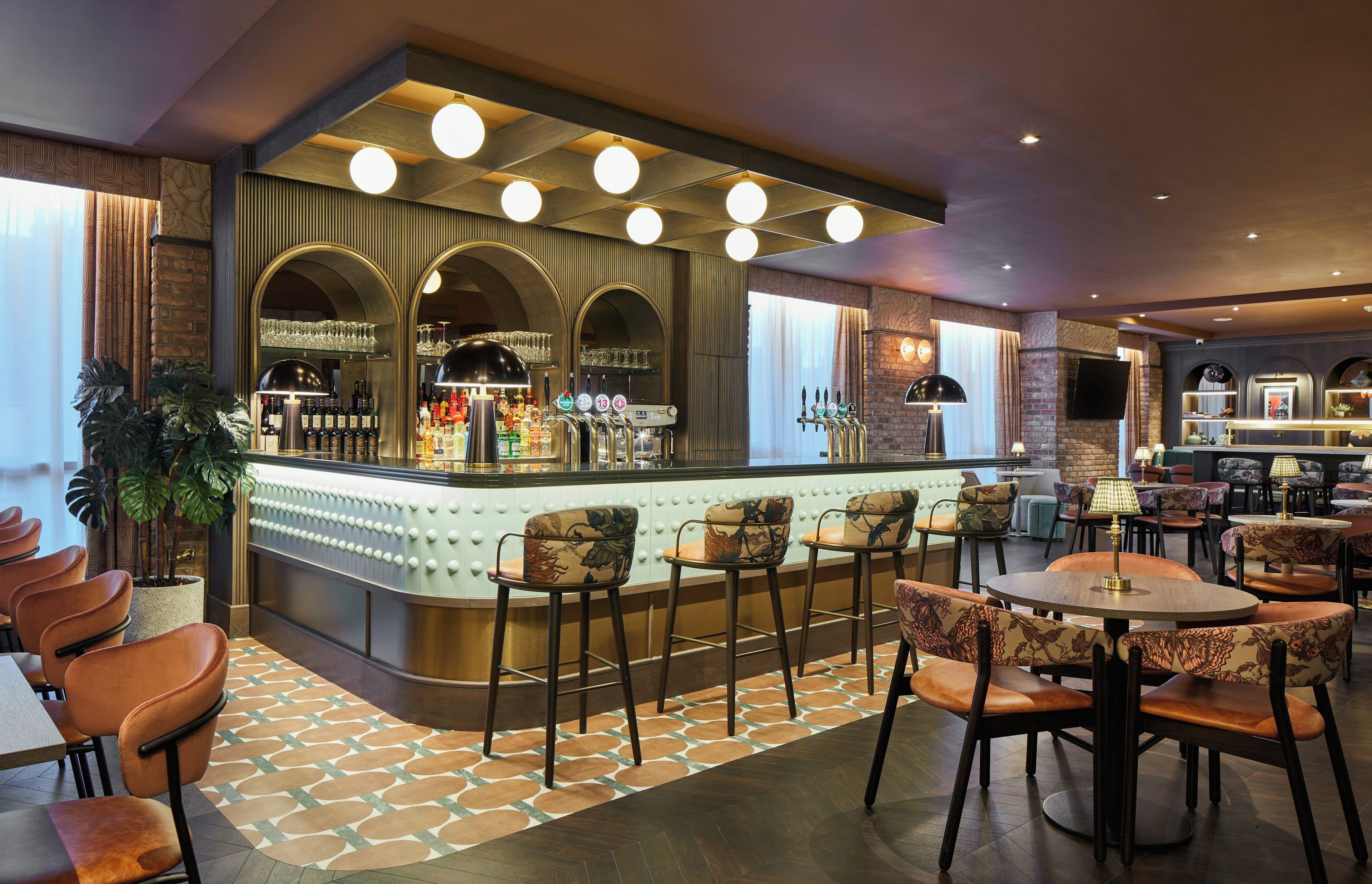 A bar area with a counter, stools, and a seating area with tables and chairs.