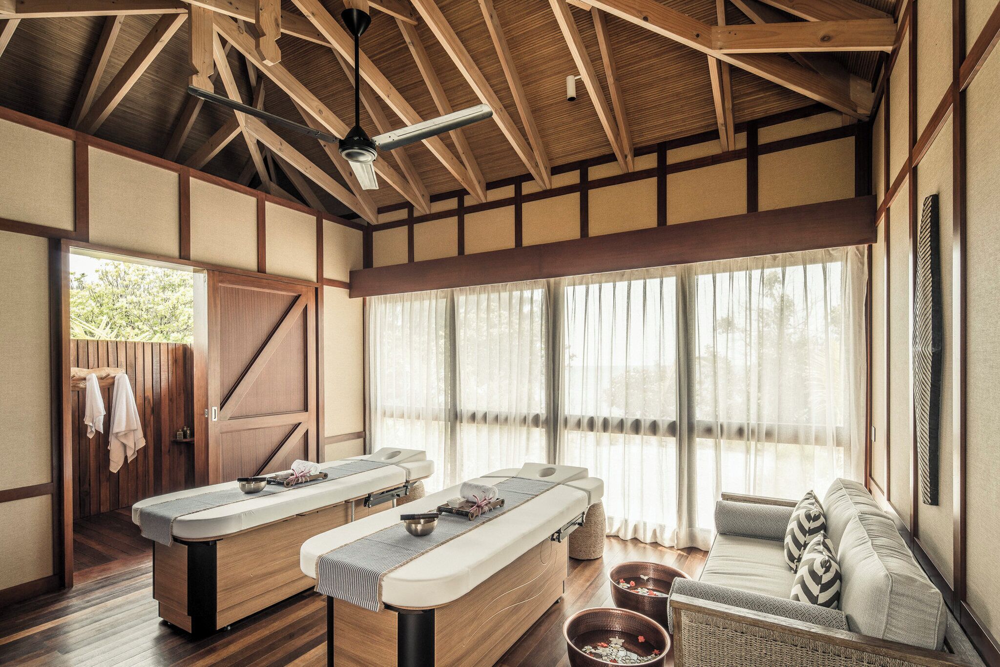 A traditional Japanese-style room with tatami flooring, a wooden ceiling, and a sliding door.