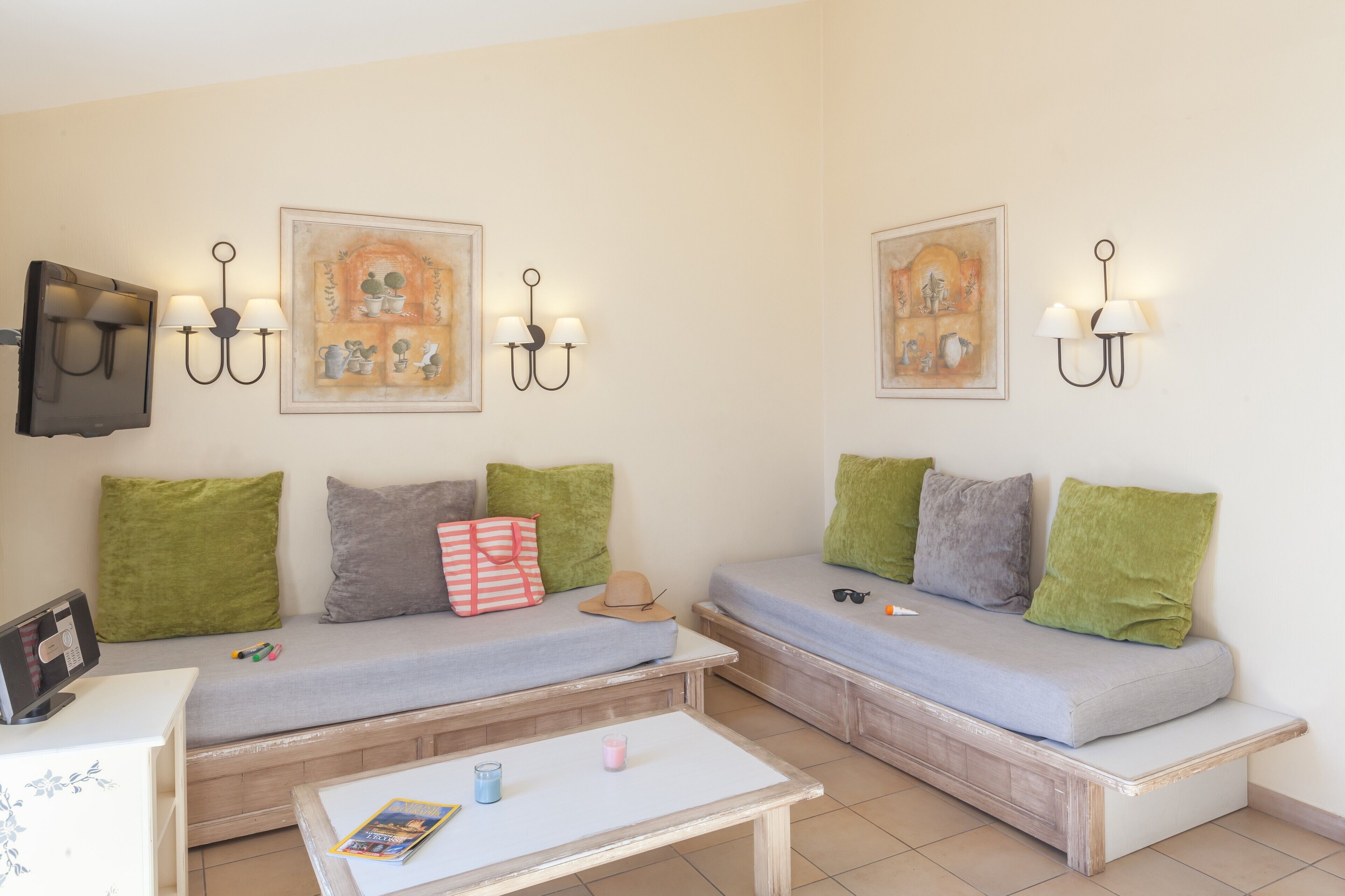 Ein gemütliches Zimmer mit zwei Sofas, einem kleinen Tisch und Wandleuchten.