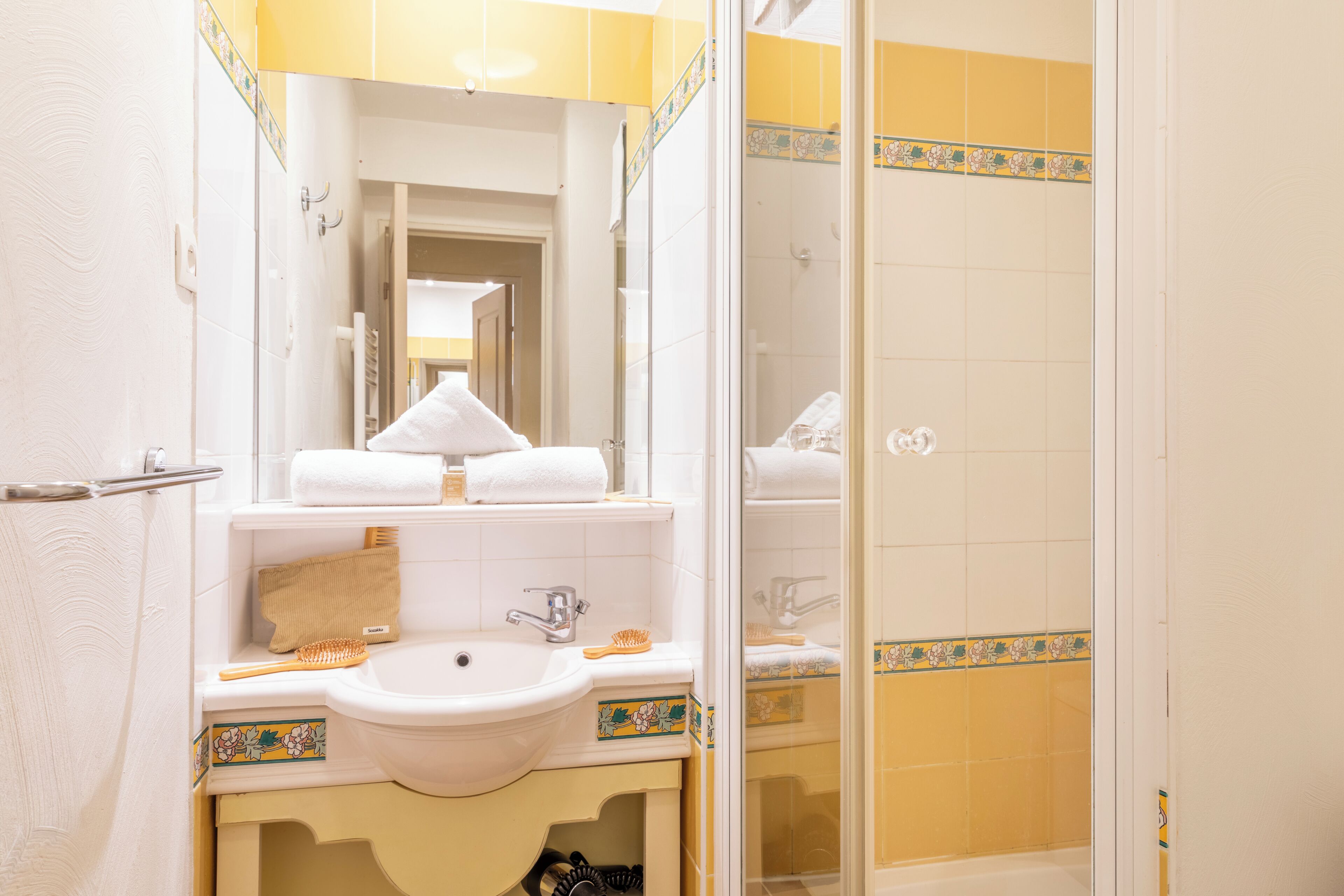 Une salle de bain avec un lavabo, un miroir et une douche.