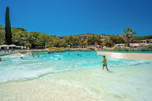 Piscina a l'aire lliure de temporada, para-sols i gandules