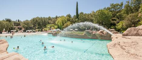Una piscina rodeada de rocas y árboles.