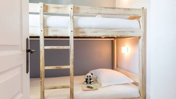 A bunk bed with a ladder, a small panda toy, and a night light.