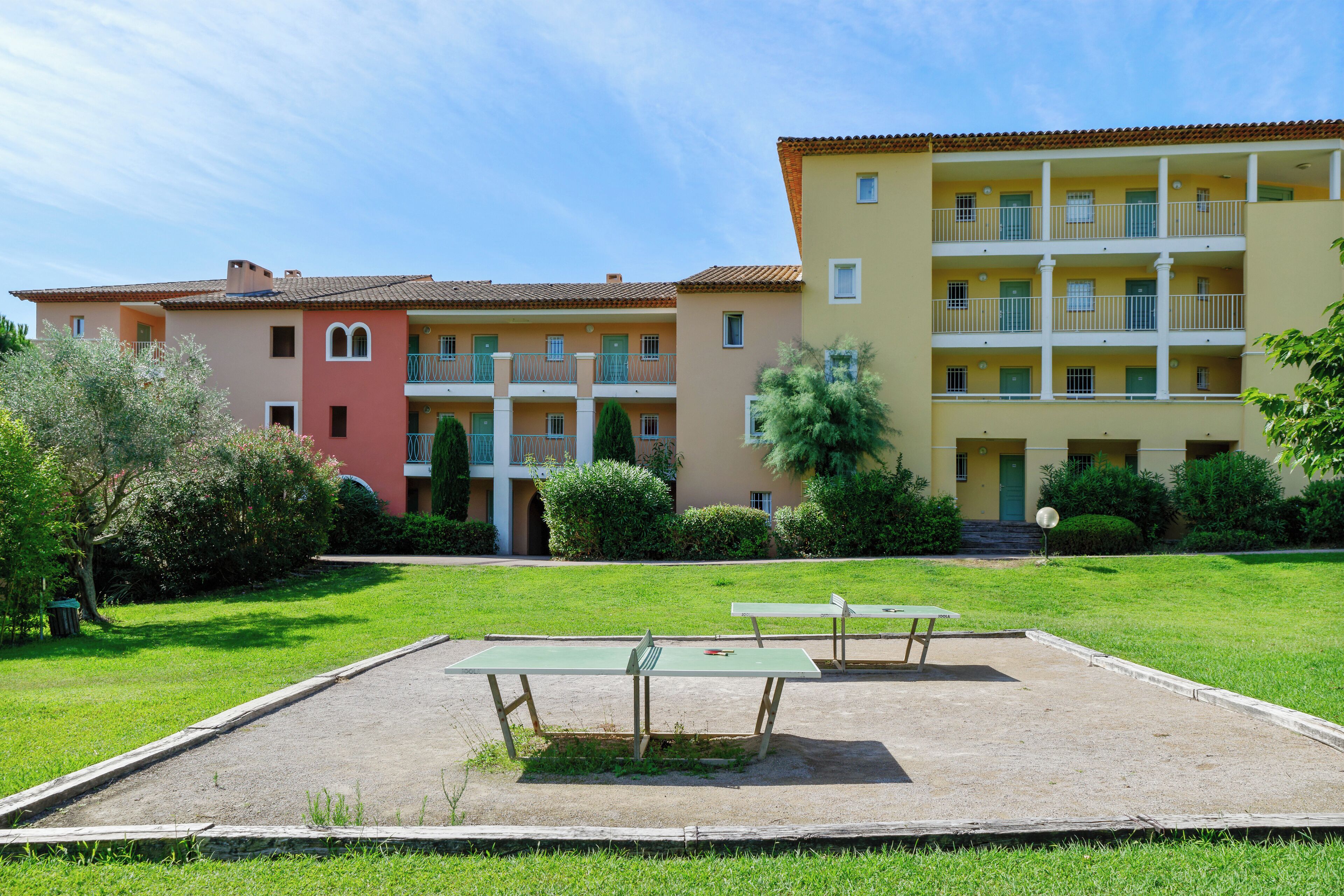 A courtyard with outdoor seating and a building with multiple balconies and windows.