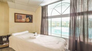 Relax in comfort with a large bed, a soothing view of the pool, and a peaceful atmosphere.