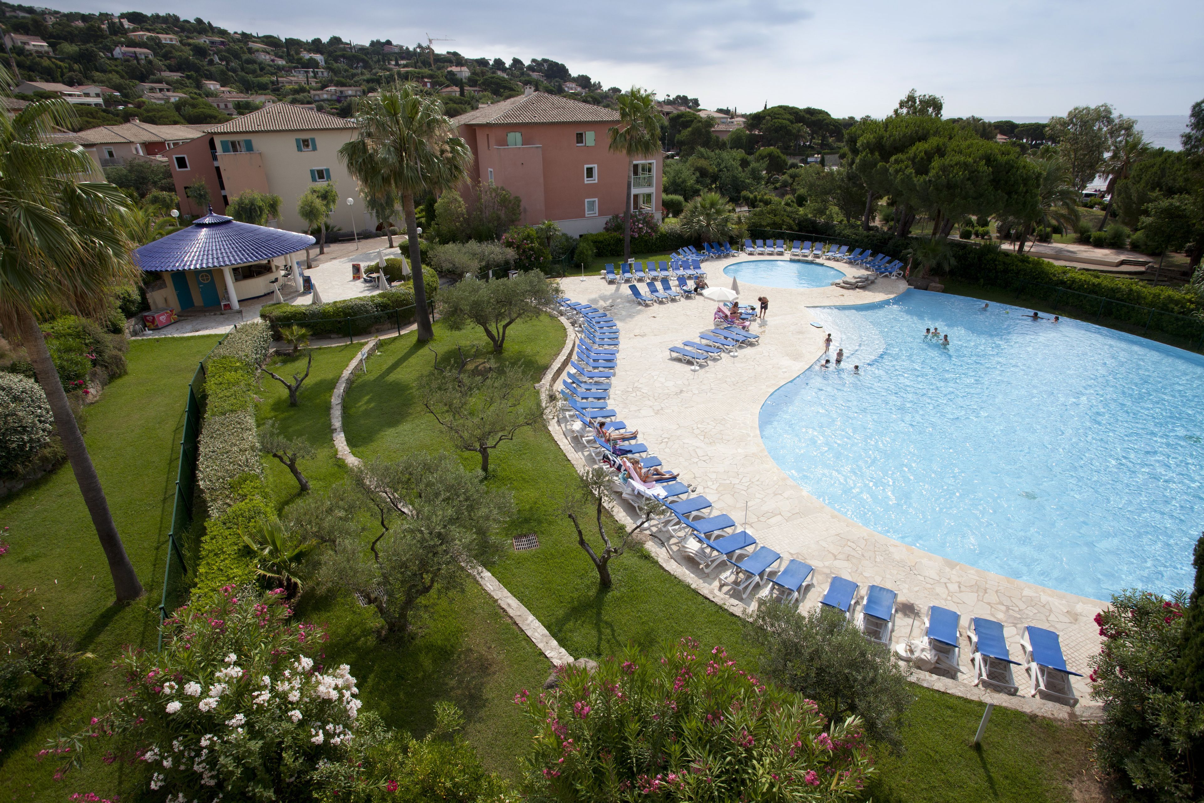 A large swimming pool with lounge chairs and a covered pavilion.