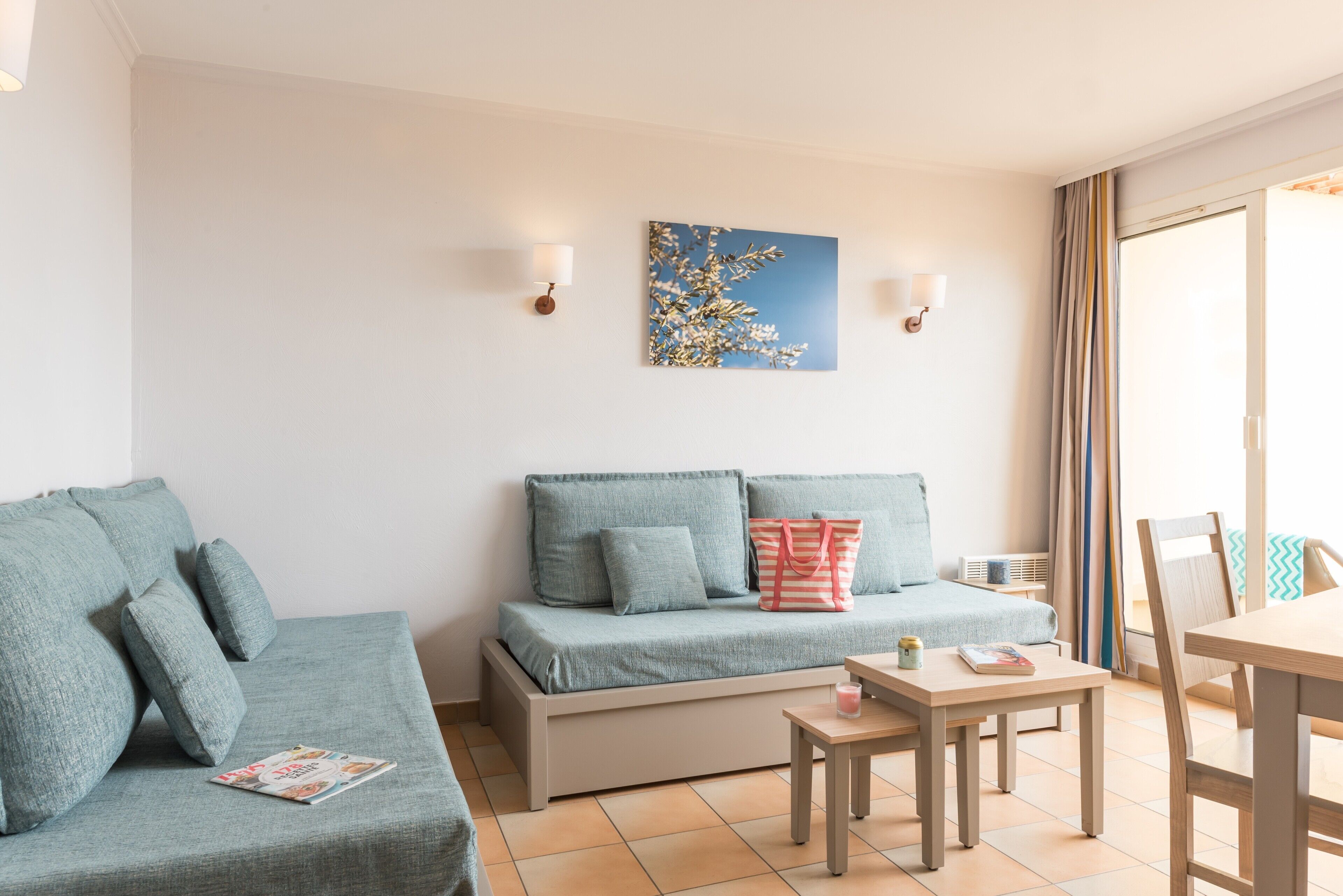 A modern living room with a sofa, a small table, and a painting on the wall.