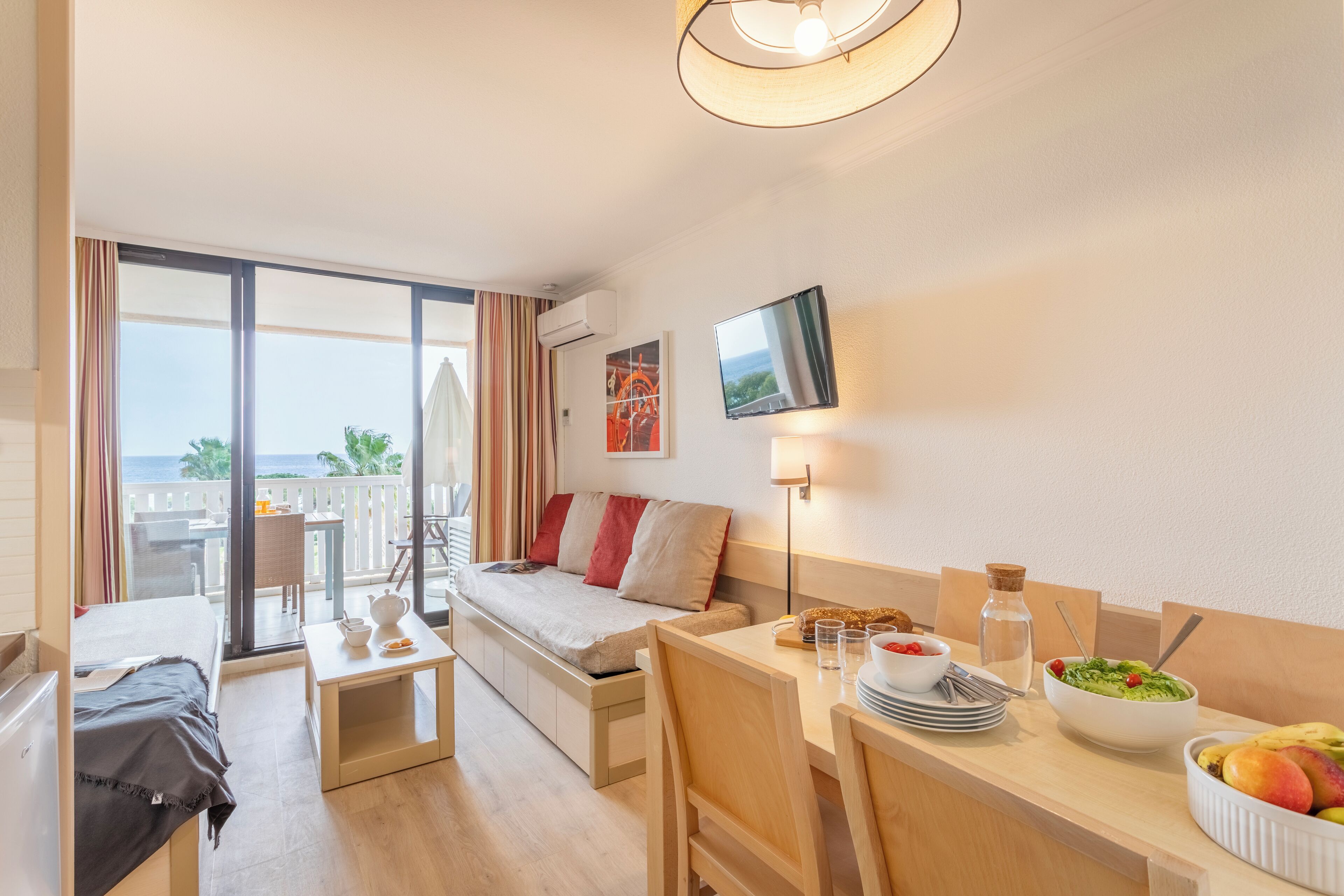 Apartment 4 people - 1 bedroom - Terrace or balcony - Air conditionned - Sea view -ExpoSud Renovated | Living area | Flat-screen TV, books