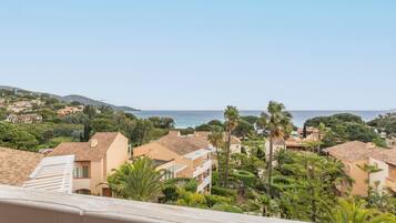 Zona residencial costera con casas escalonadas, palmeras y vista al mar.