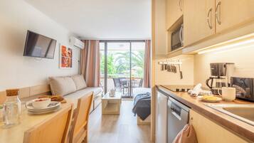 Appartement 4 personnes - 1 chambre - Terrasse ou balcon - Climatisé | Coin séjour | Télévision à écran plat, livres