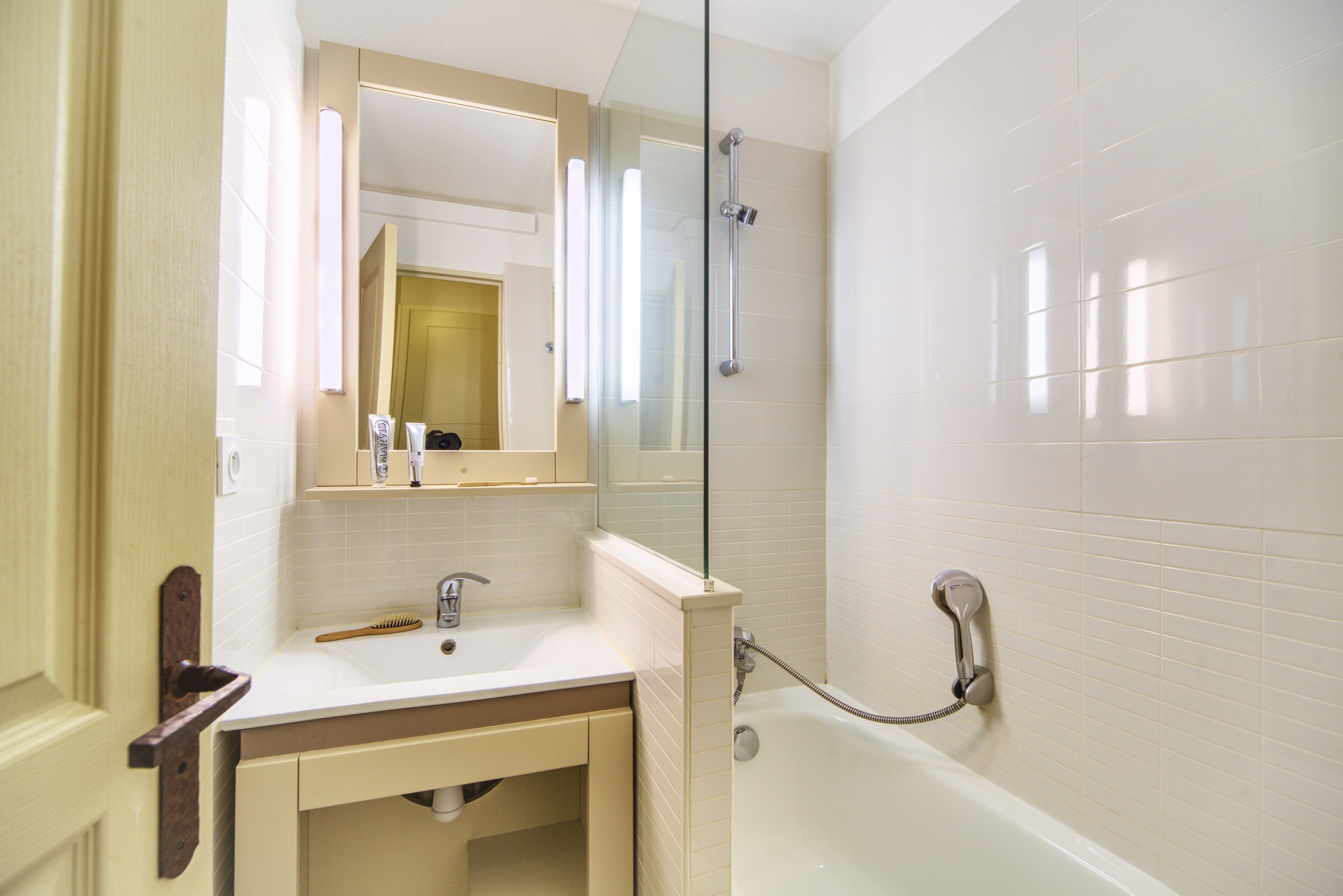 Un baño con cabina de ducha de vidrio, un lavabo con espejo y una bañera.