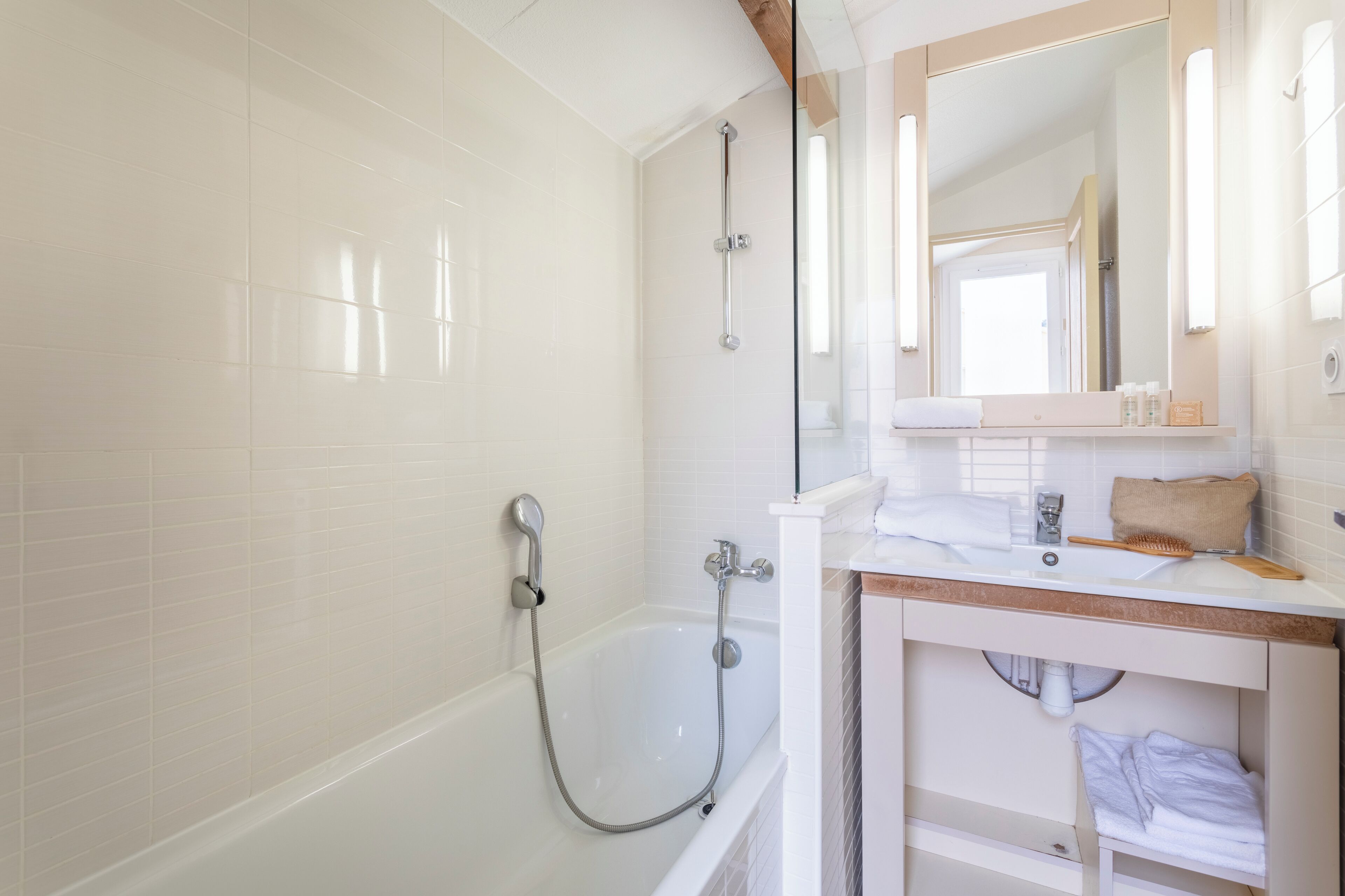 Une salle de bain moderne équipée d’une baignoire, d’une douche et d’un meuble-lavabo avec un miroir.