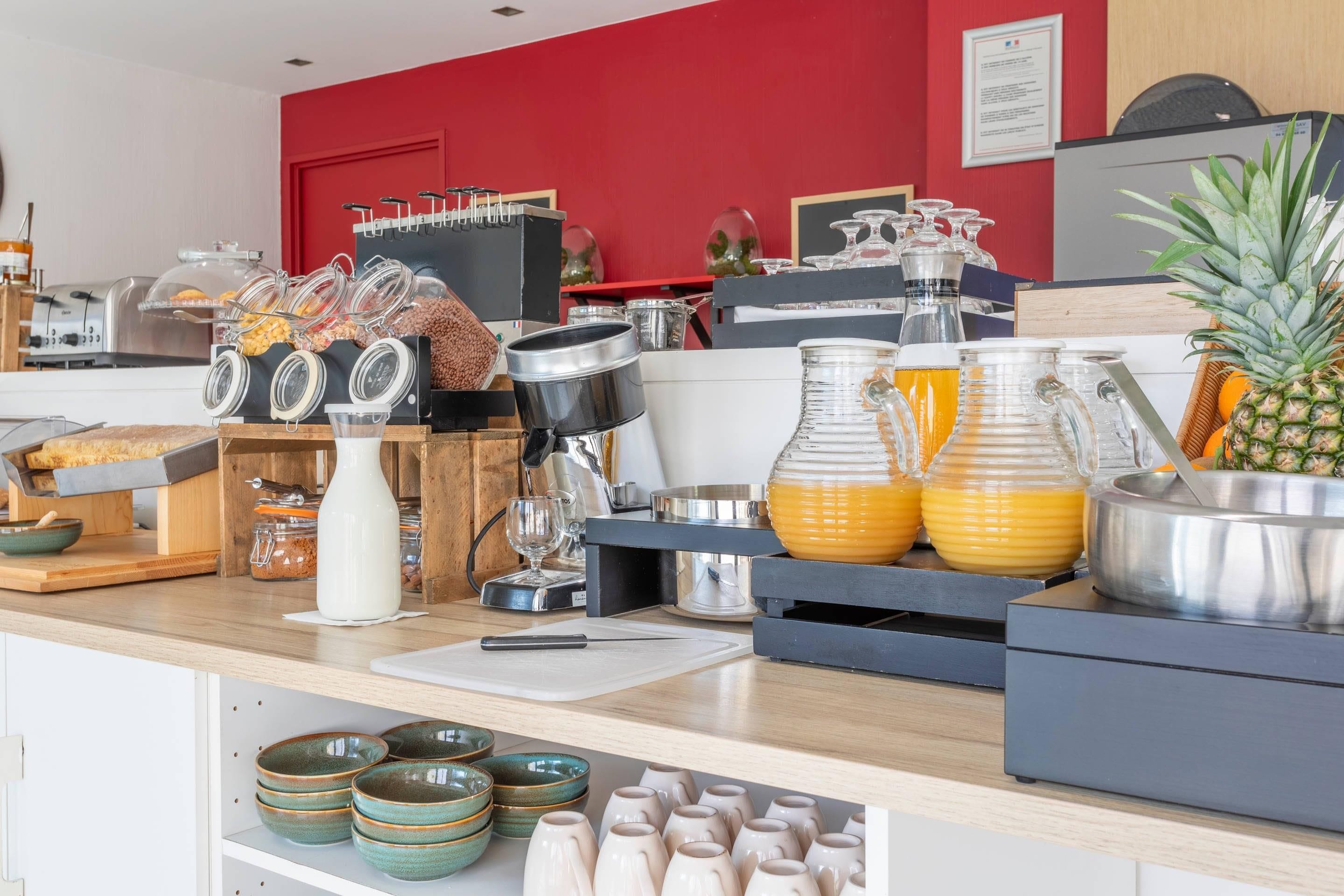 Un bufé de desayuno con diferentes opciones de comida, una máquina de café y una exhibición de frutas.