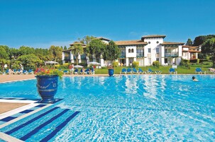 Una piscina al aire libre de temporada, sombrillas