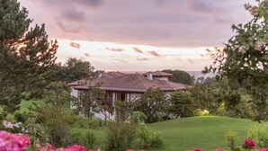 A house with a tiled roof, surrounded by greenery and flowering plants. - Pierre & Vacances Residence Le Domaine de Bordaberry (Urrugne)