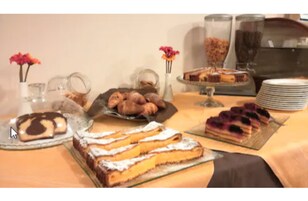 Una mesa de buffet con diversos postres y pasteles.