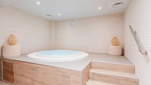 A modern bathroom with a freestanding bathtub, wooden steps, and a wall-mounted clock. - Pierre & Vacances Premium Le Domaine de Cramphore (Le Pouliguen)