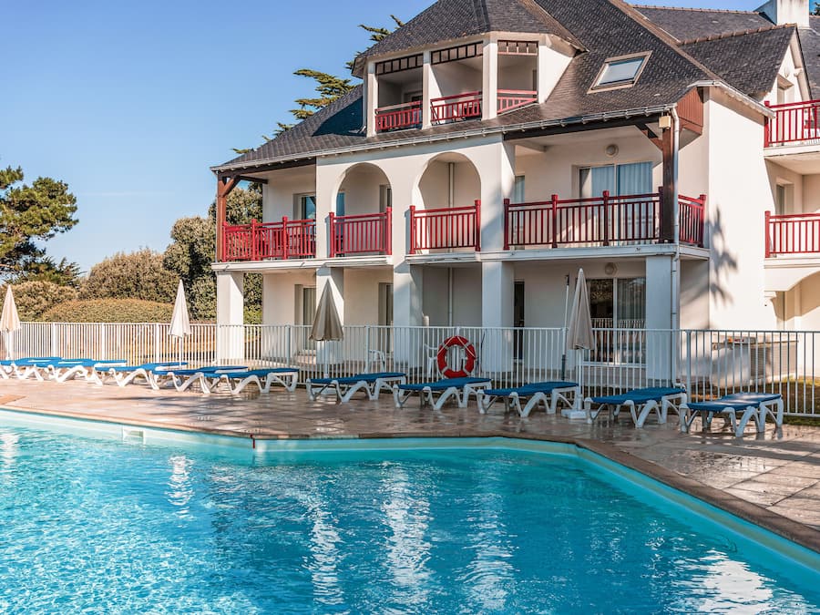 En säsongsöppen utomhuspool, parasoller och solstolar