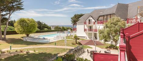 Propiedad residencial con piscina, zona de estar al aire libre y vista al mar.