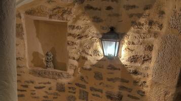 Una escalera de piedra con un farol en un hueco.