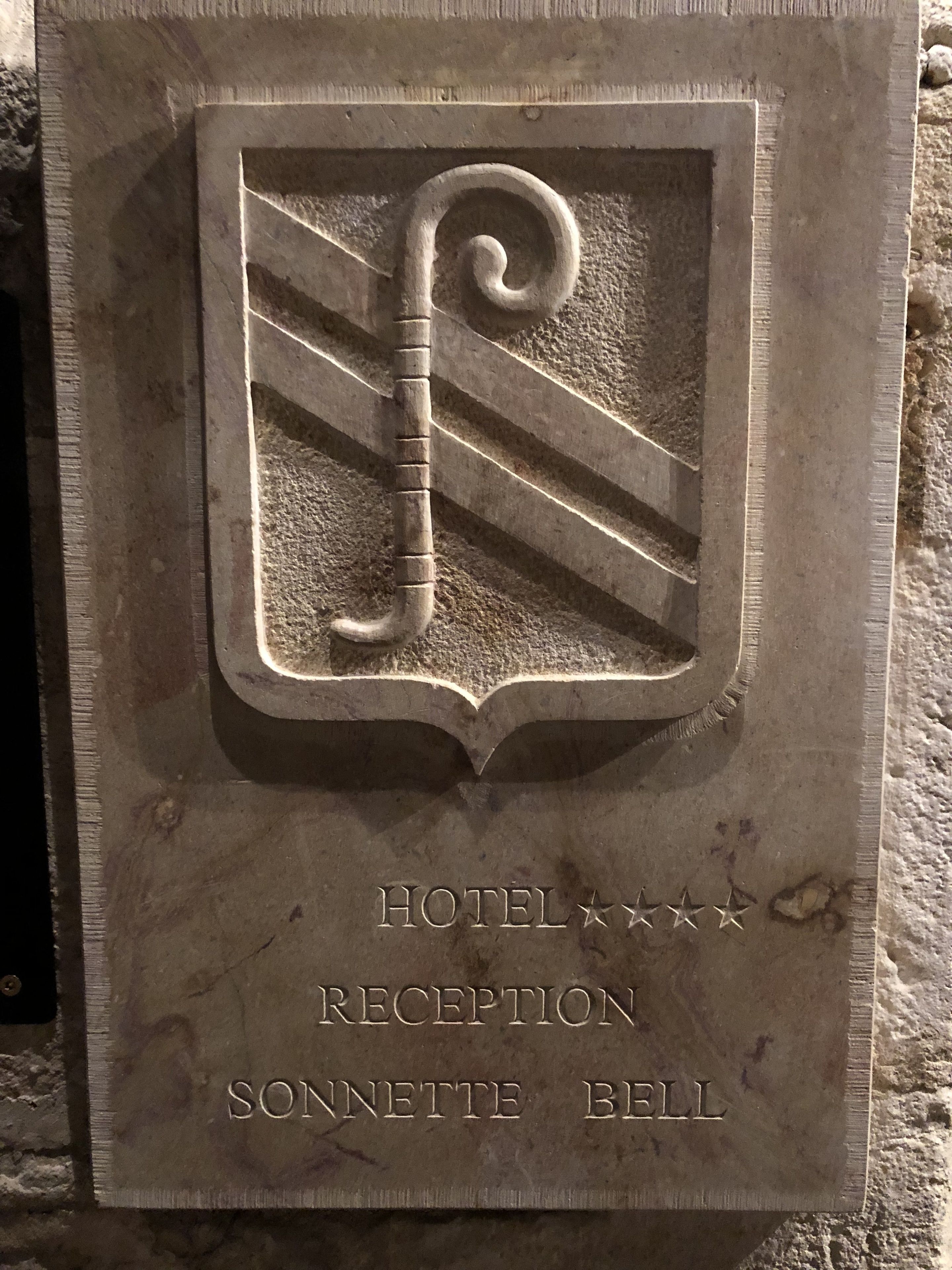A stone plaque with the inscription "HOTEL RECEPTION SONNETTE BELL".