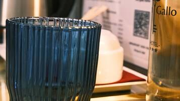 Un verre bleu sur un plateau, avec une bouteille de vin Gallo et un menu en arrière-plan.