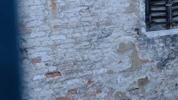 A weathered building facade with a window and a door.