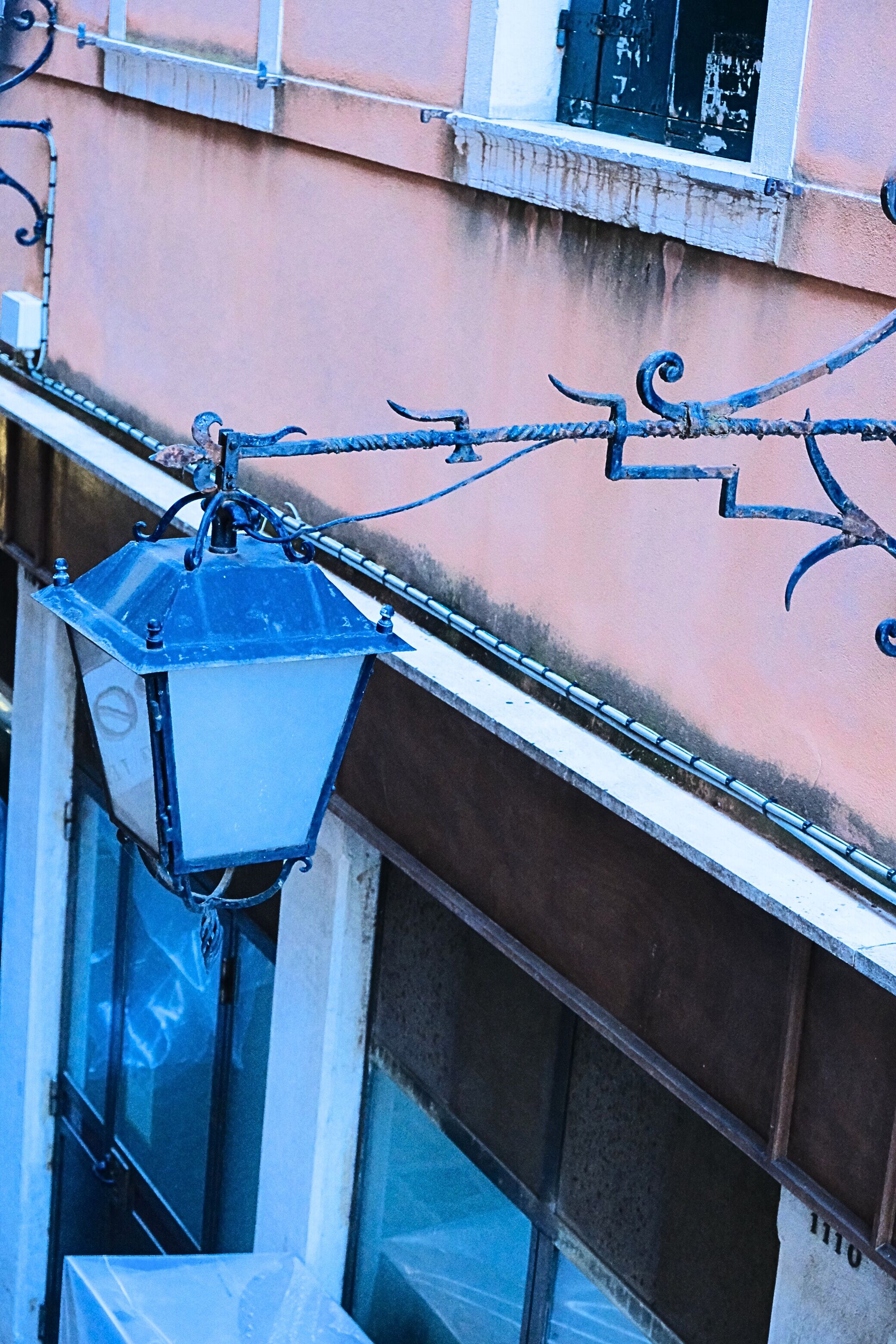 A building with a metal lantern hanging from the exterior.