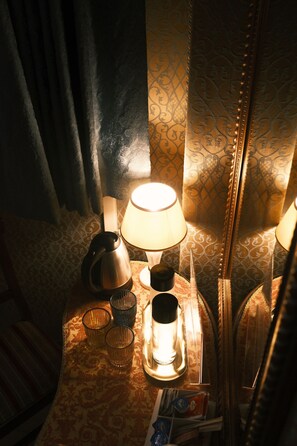 A bedside table with a lamp, a kettle, and a tray with a cup and a tissue box. - Hotel San Gallo (Venice)