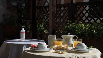 Una mesa dispuesta con cosas para el desayuno, incluyendo una botella de leche, una jarra de zumo de naranja y una tetera.