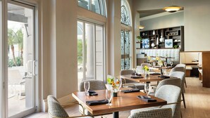 Un restaurante con amplios ventanales, techos altos y un diseño de interiores moderno.