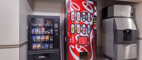 A vending machine and a refrigerator in a commercial setting.