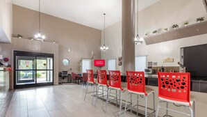 Een ruime keuken met moderne apparatuur, een ontbijtbalk met rode stoelen, en een bord dat gratis Wi-Fi aanbiedt.