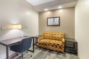 A small, private office with a desk, chair, and sofa.