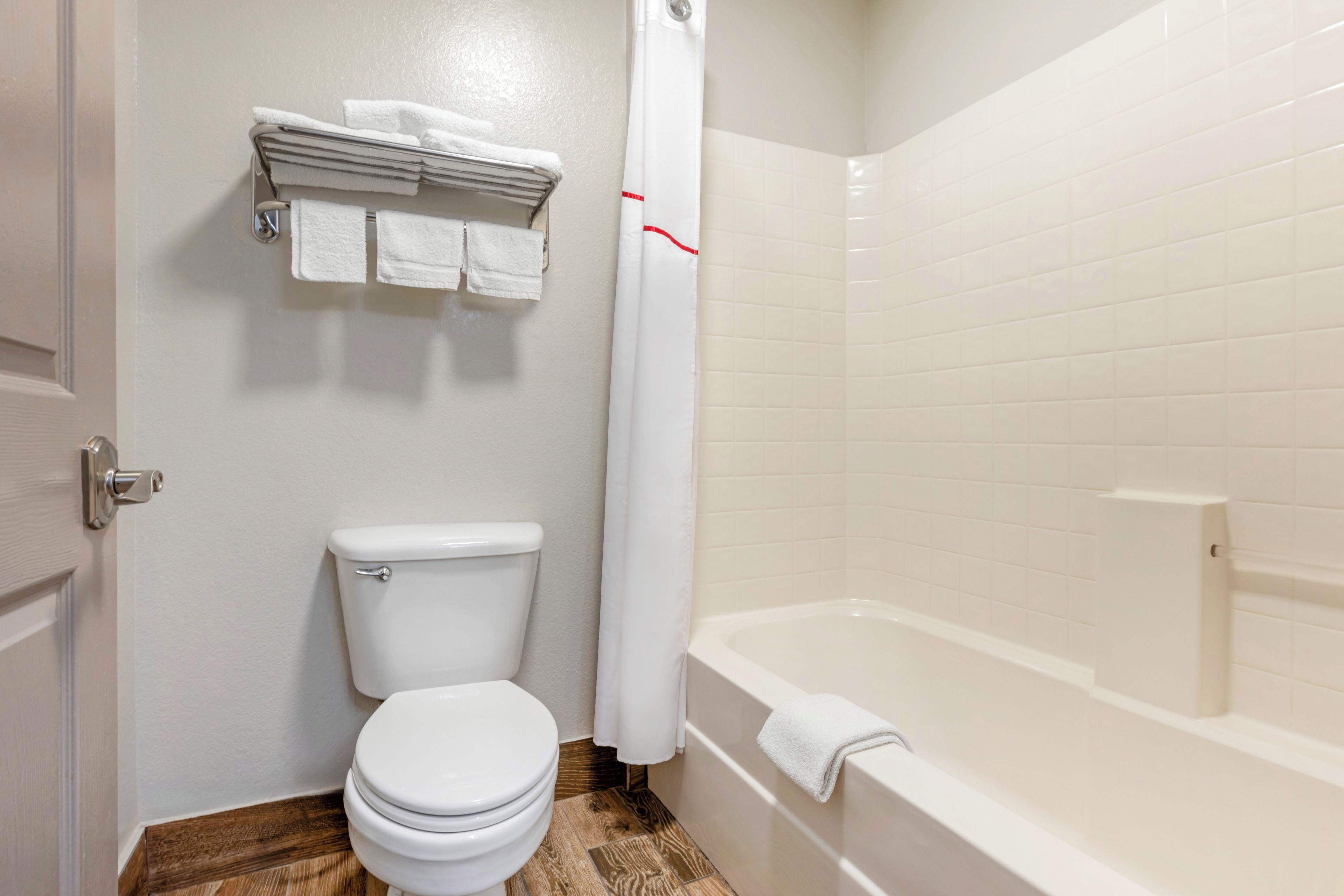 A bathroom with a toilet, a bathtub, and a shower curtain.