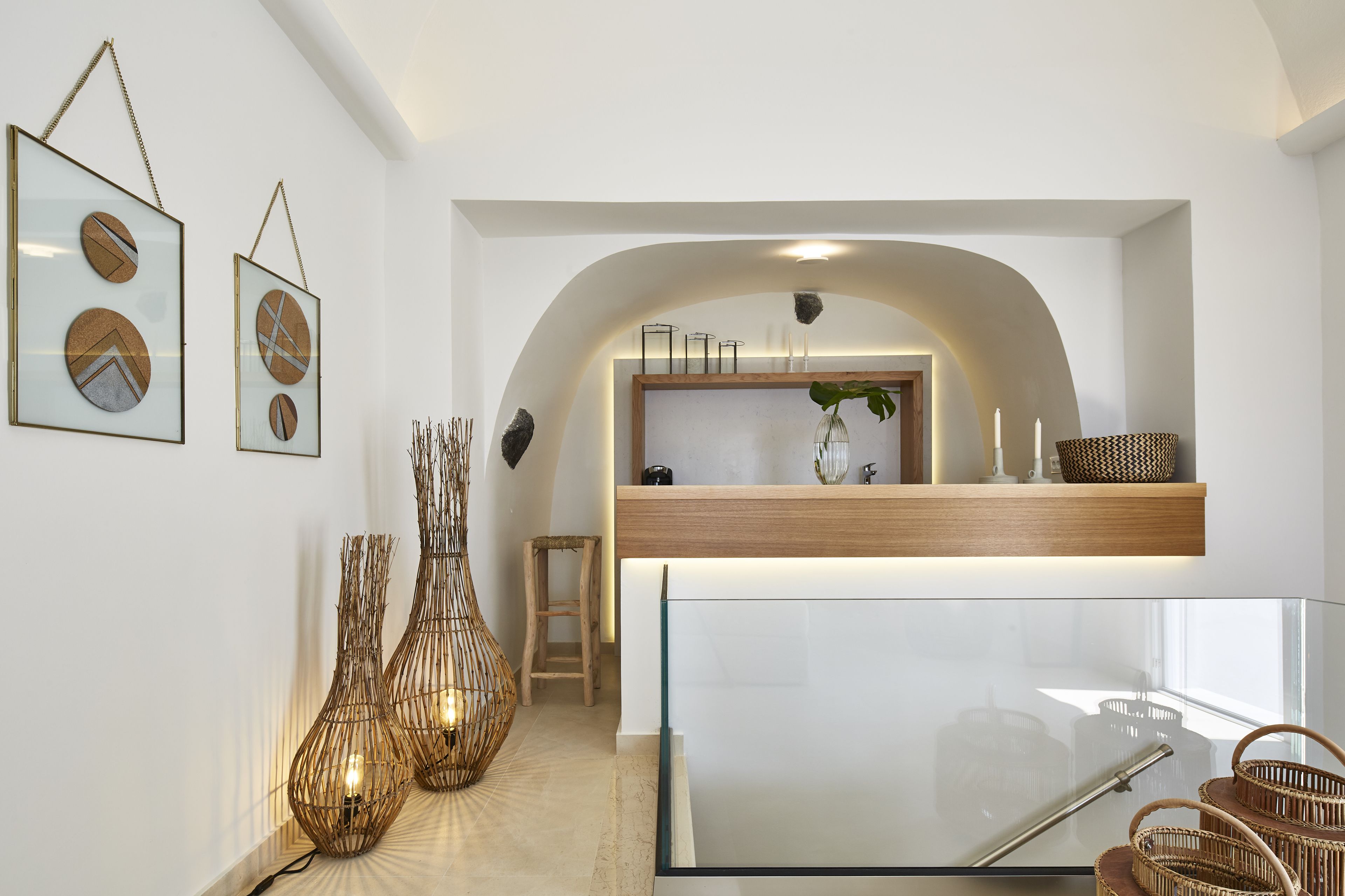 A modern interior with a reception desk, framed artwork, and wicker furniture.