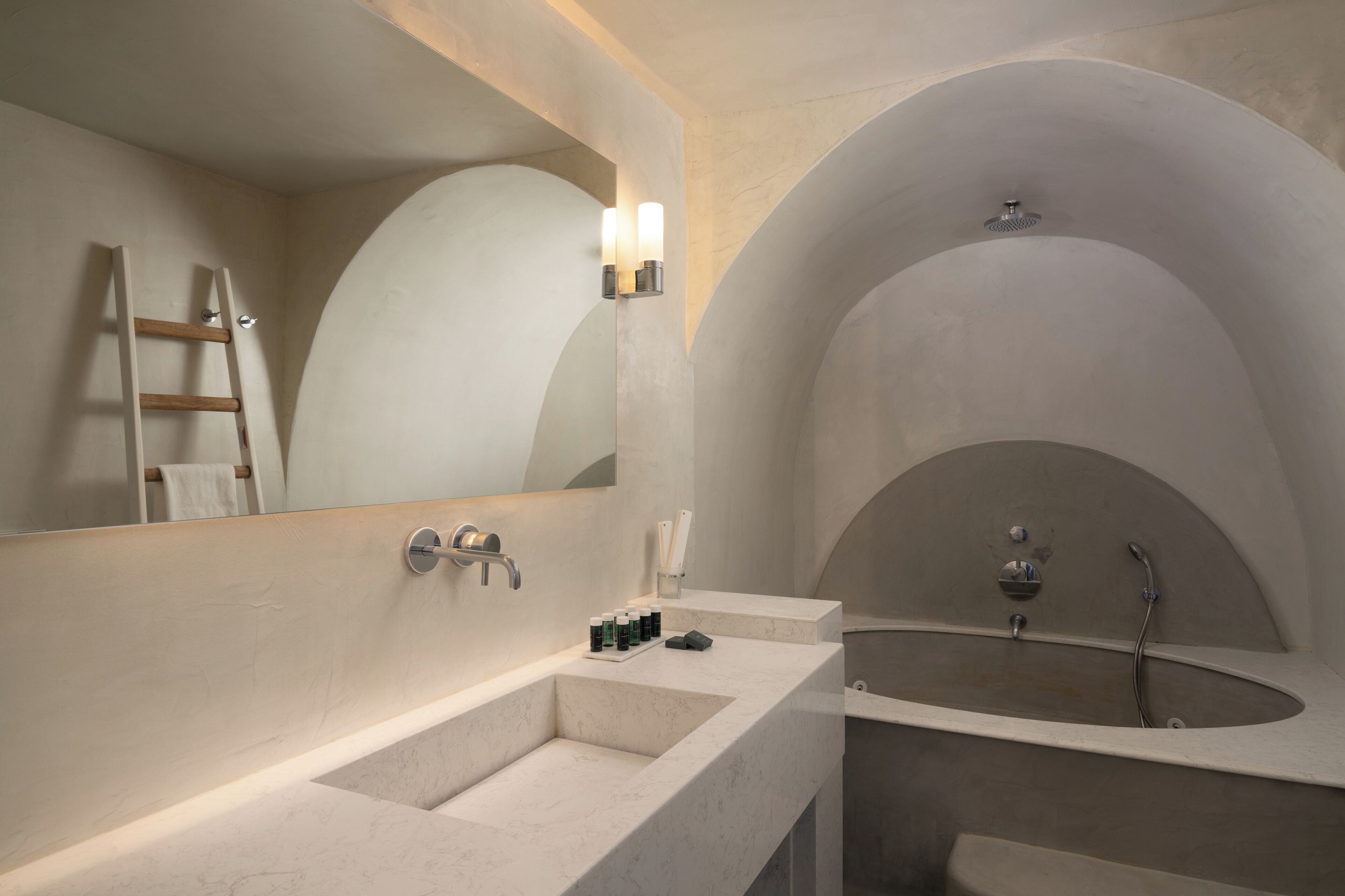 Un baño moderno con un lavamanos grande, una bañera y un espejo con luces empotradas.