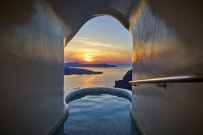 A view from a bathtub to a sunset over water, with a clear sky and distant land. - Volcano View Hotel Santorini (Santorini)