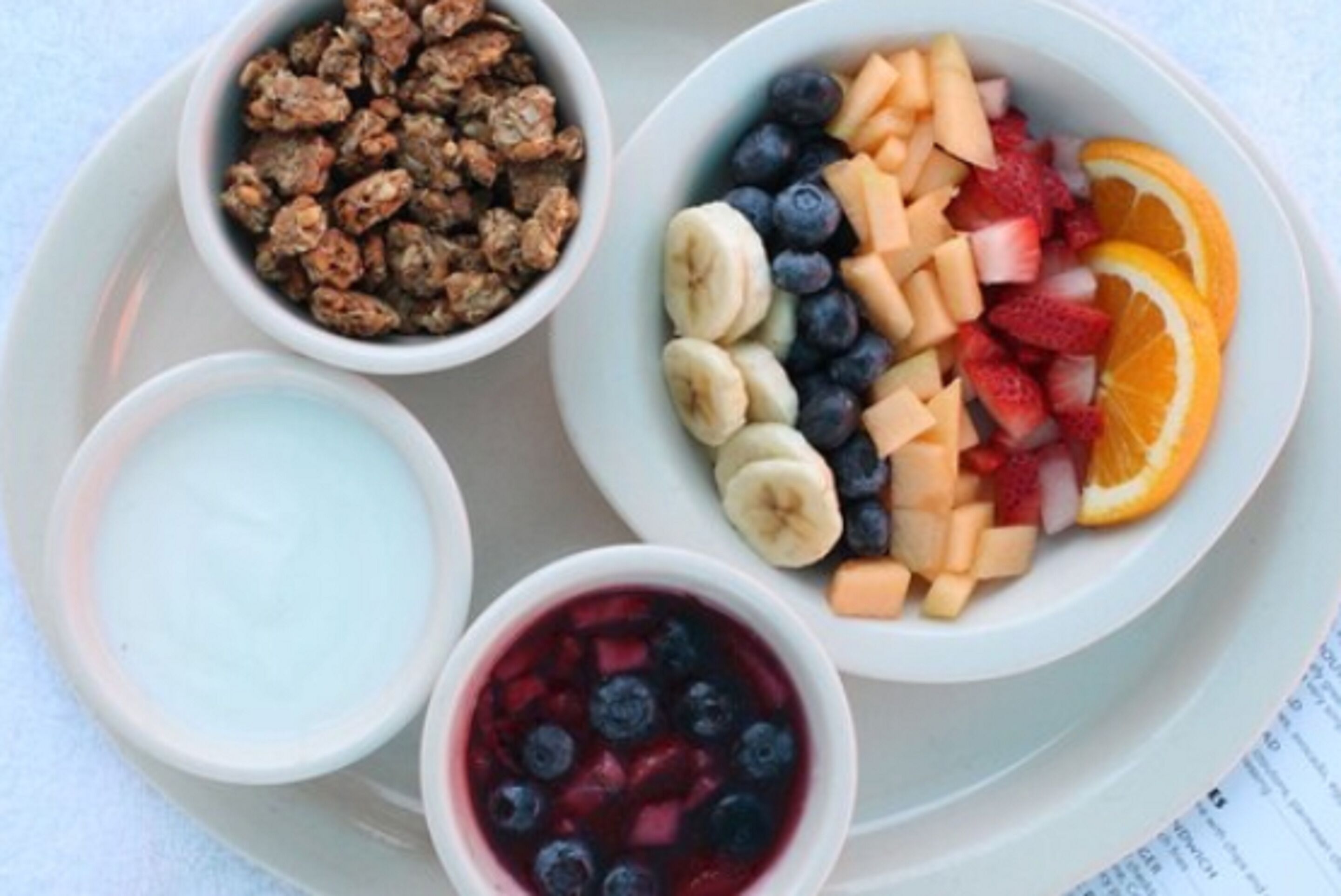 Een ontbijfwagen met ontbijstgranen, yoghurt en fruit.