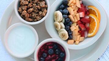 Een ontbijfwagen met ontbijstgranen, yoghurt en fruit.