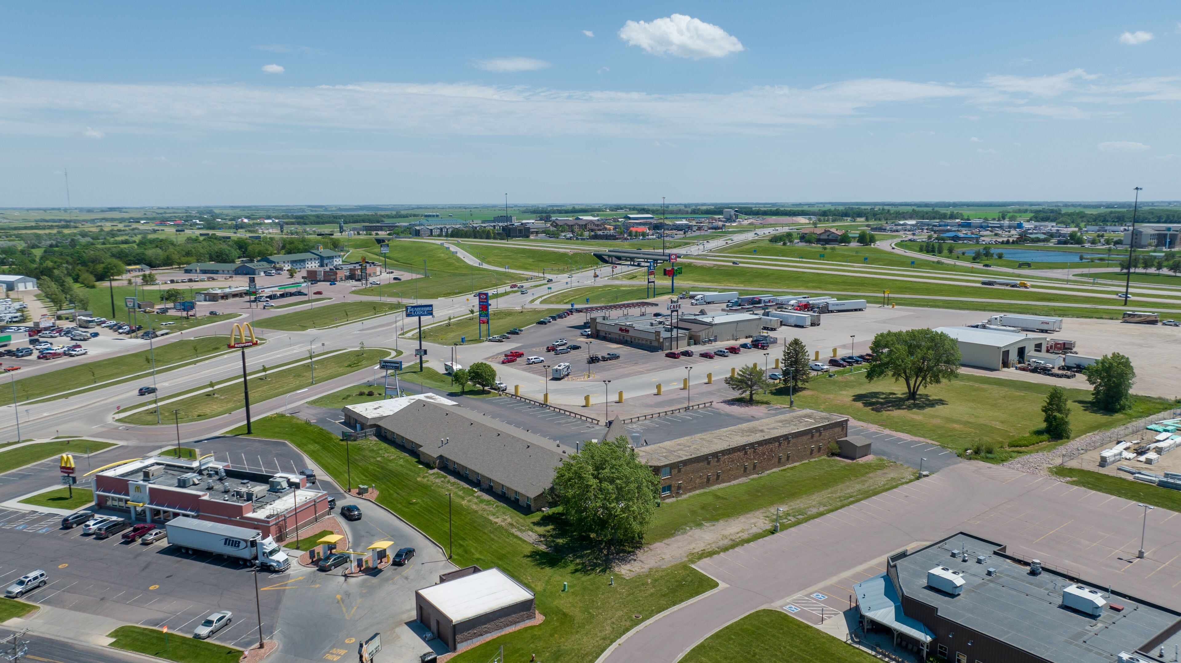 A commercial area with a McDonald's, a parking lot, and a large building with a flat roof.