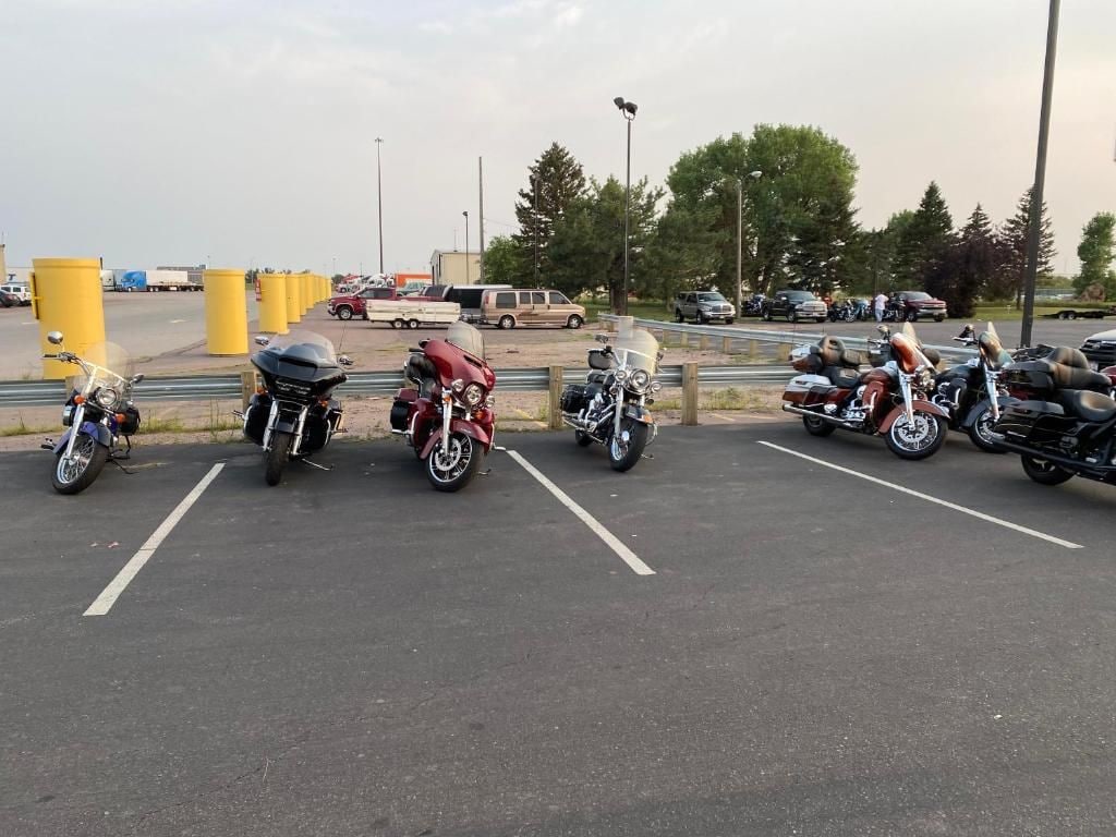 Um estacionamento com motocicletas e carros.