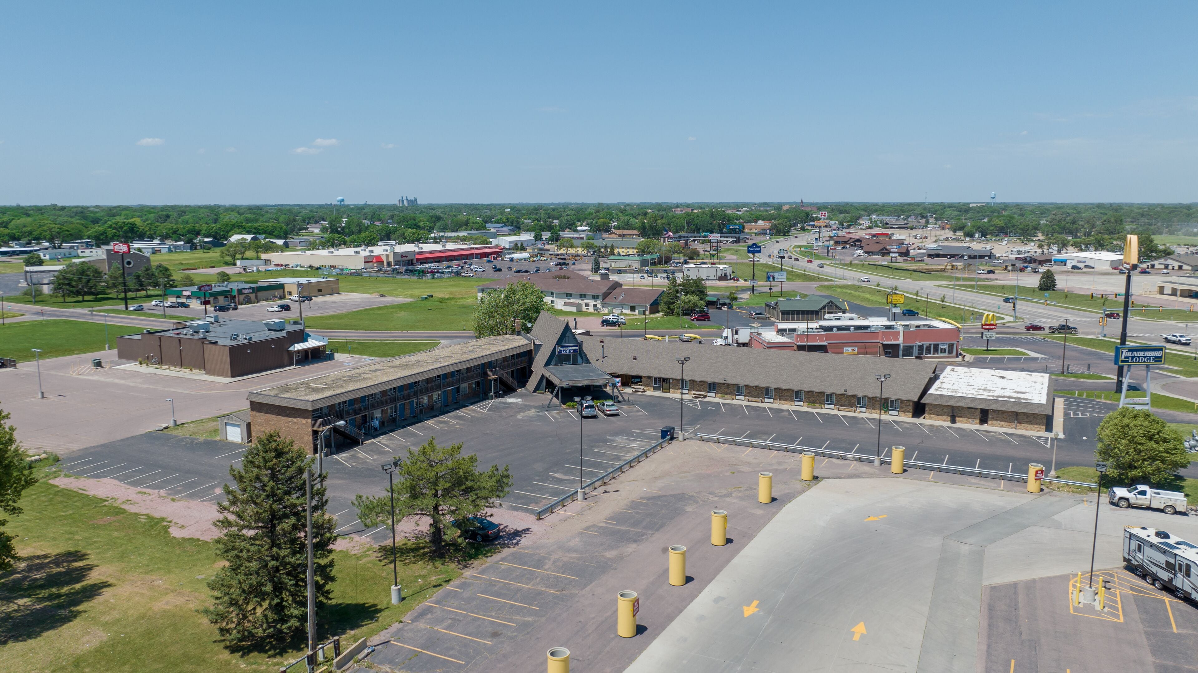 A large parking lot with multiple buildings, including a prominent structure with a pointed roof and a sign for a hotel.