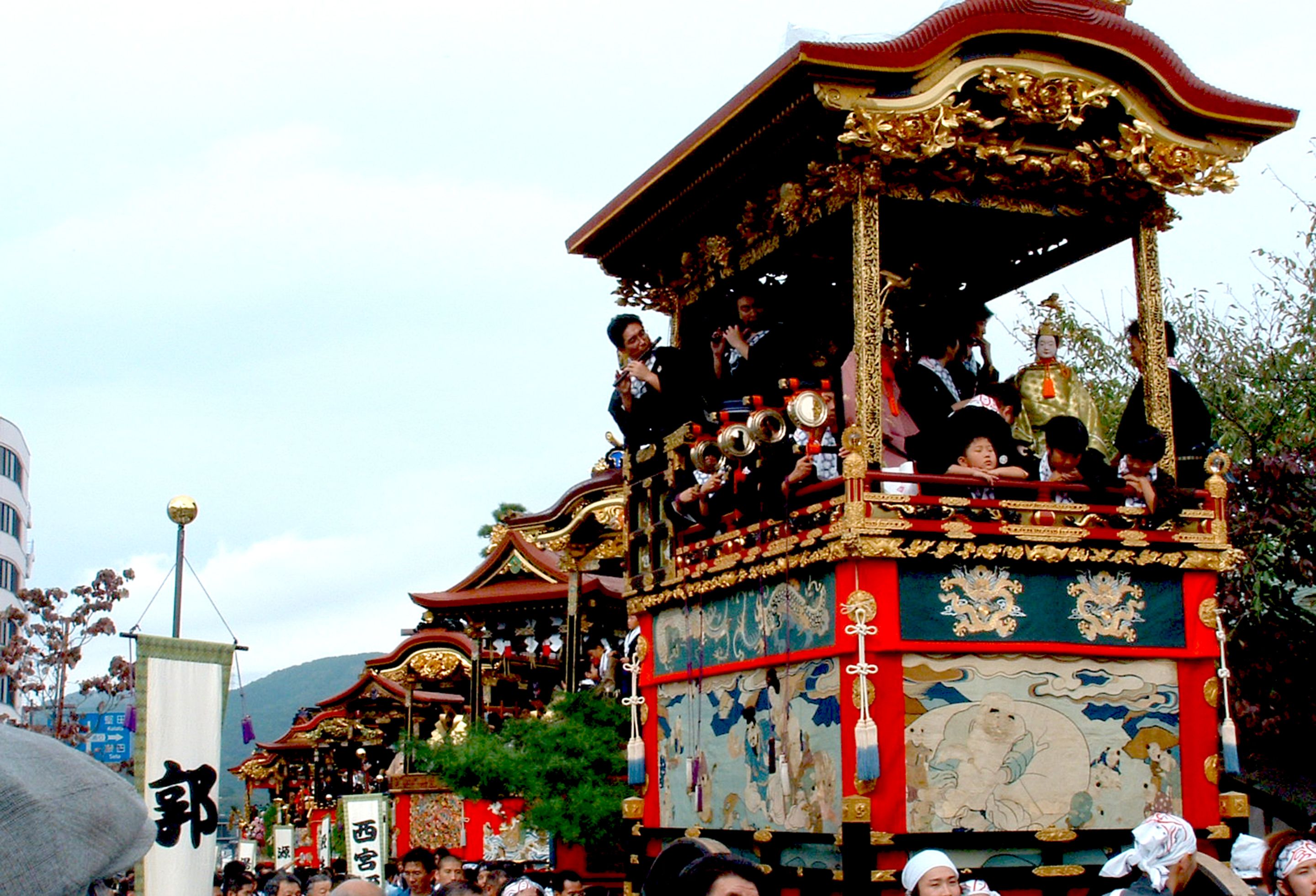 A traditional ornate carriage with intricate designs and a crowd of people around it.